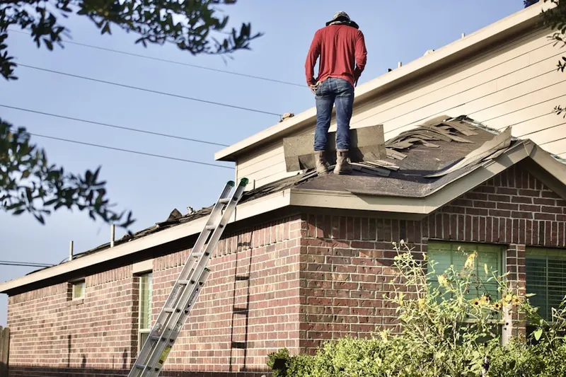Professional roofer working on a residential roof in Hillsdale Manor